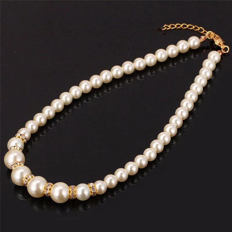 Pearl necklace with gold-tone crystal accents and a clasp chain