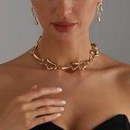 Gold-tone lava-drop choker necklace and dangling drop earrings on model