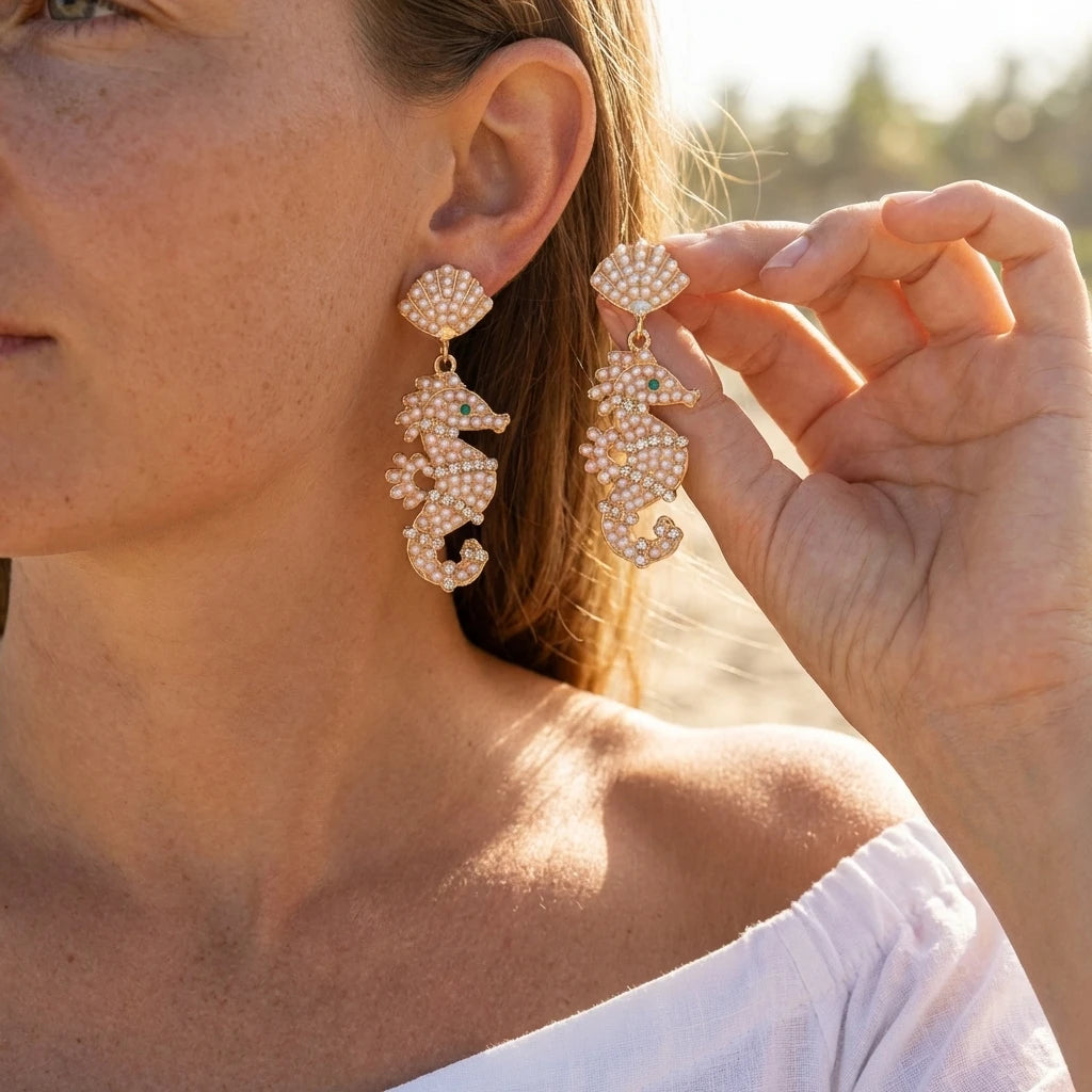 Pearl seahorse drop earrings with dangling shell shapes, gold-tone setting