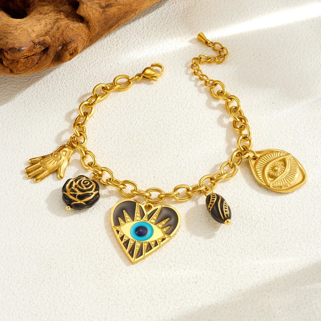 Gold evil-eye hamsa charm bracelet with blue eye heart, hamsa hand, and rose charms