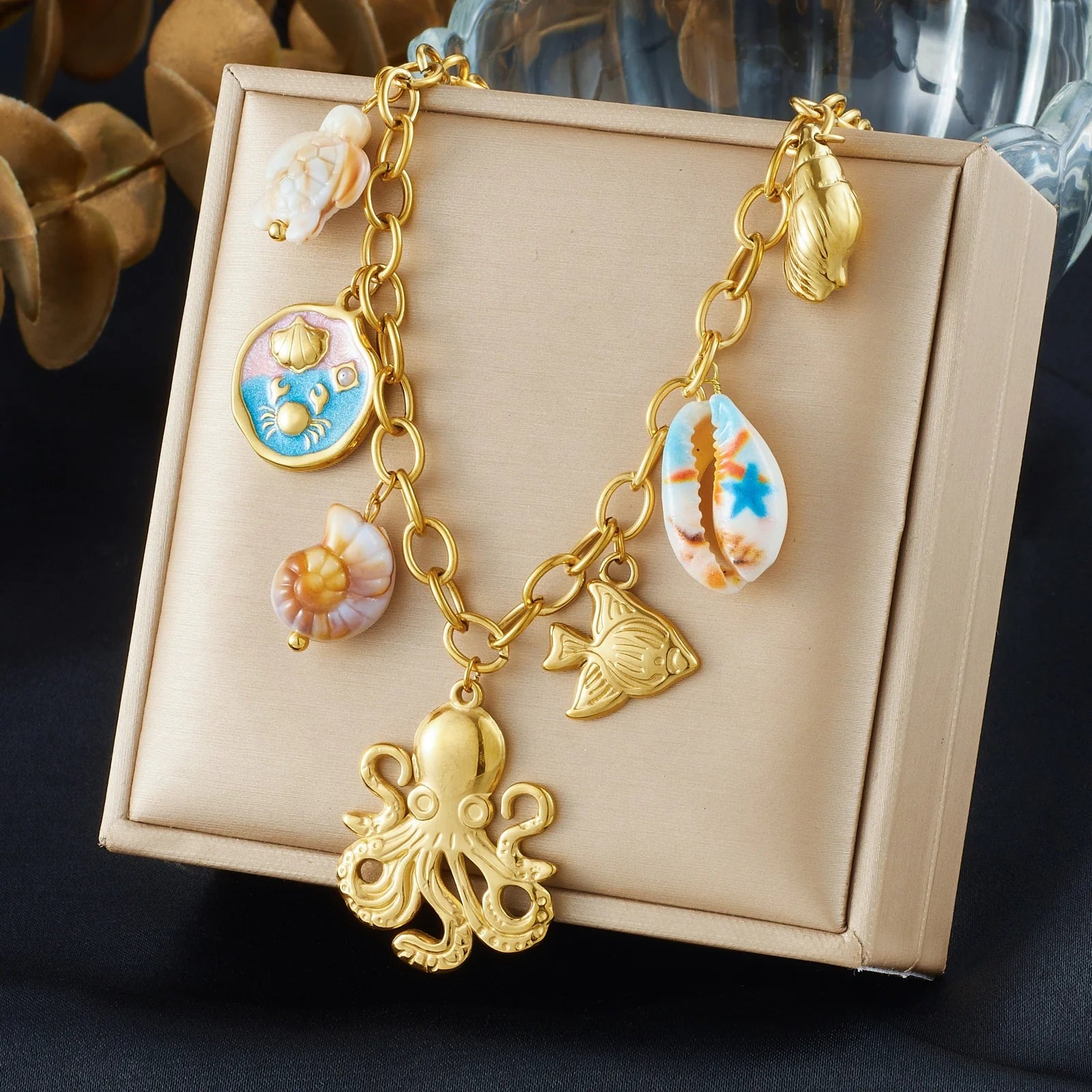 Gold-tone octopus shell pendant necklace with multiple sea charms, lobster-claw clasp
