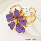 Flower cuff bangle bracelet with gold-tone band and purple enamel flower, pearl center.