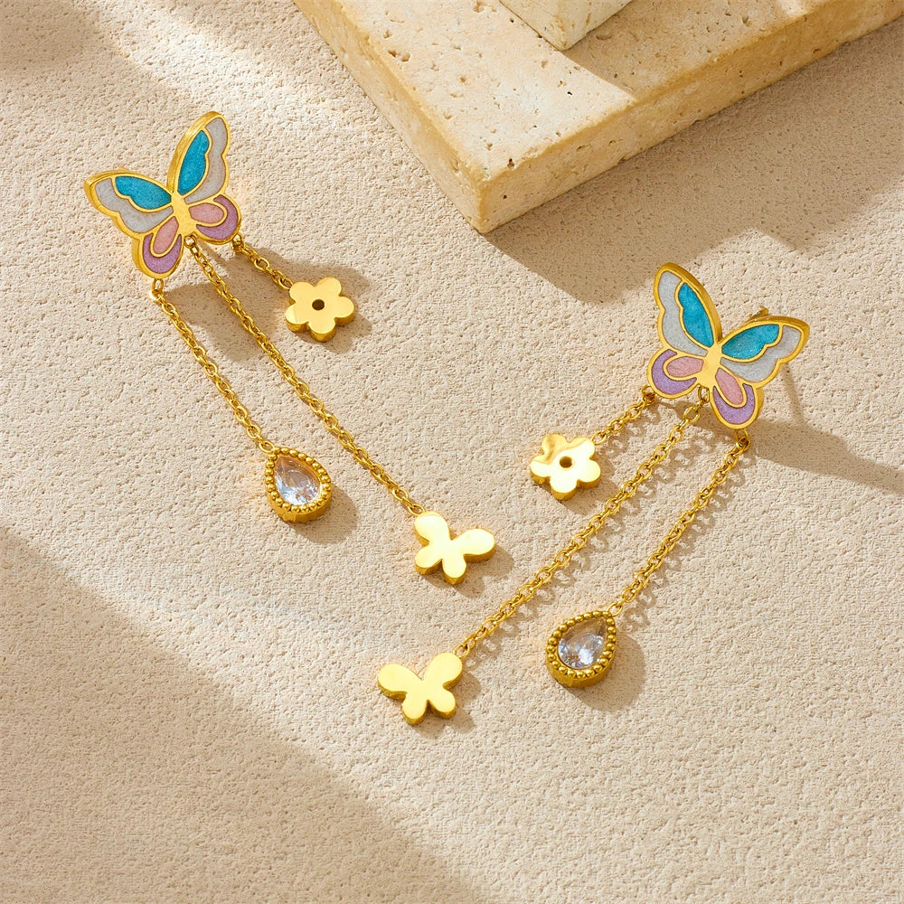 Gold-tone butterfly drop earrings with blue enamel wings, flower and teardrop crystal charms