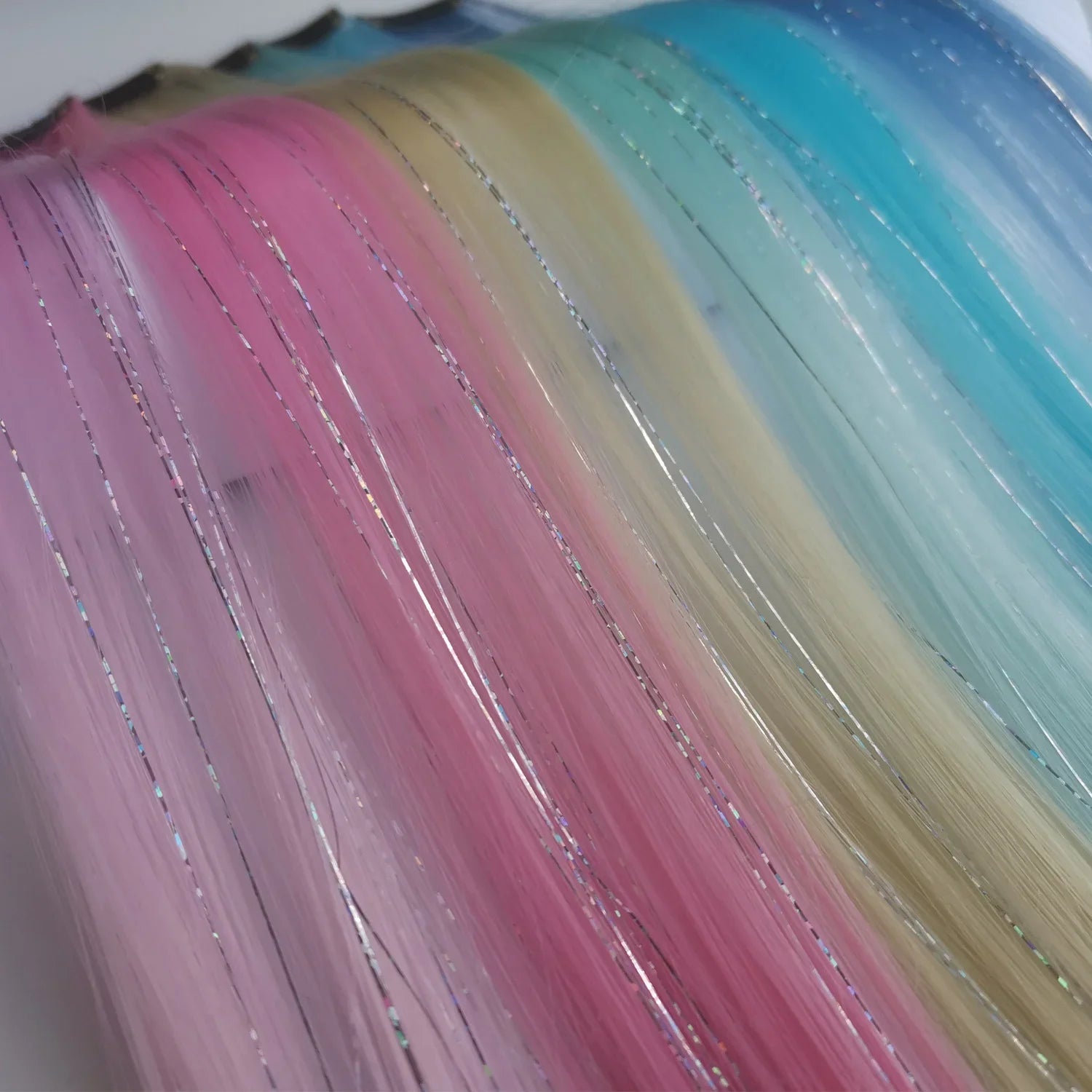 Rainbow hair tinsel strands in pink, purple, and blue with fine sparkling highlights