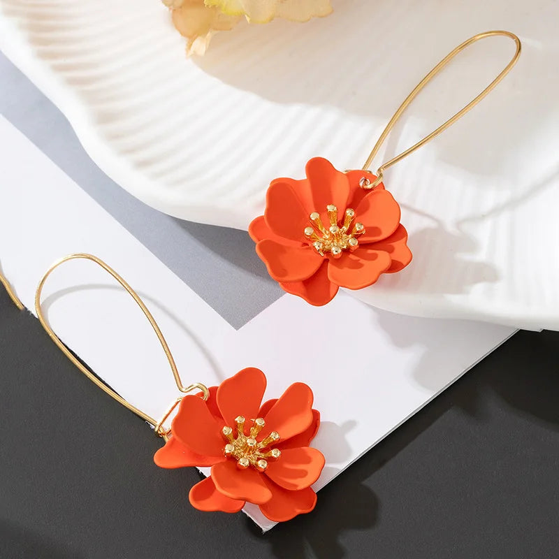 Floral stud earrings with layered orange flower petals and gold-tone hooks