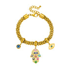 Gold-tone beaded chain bracelet with blue eye charms and center hamsa hand pendant