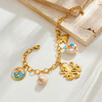 Gold-tone shell charm necklace with octopus pendant and blue enamel shell and bow charm.