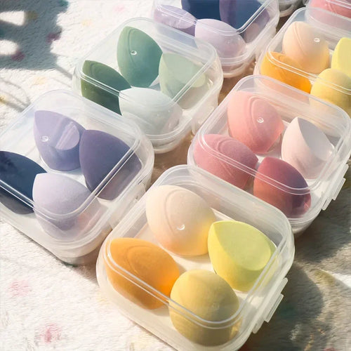 4-piece makeup sponge set in clear cases with green, pink, navy, and yellow teardrop sponges