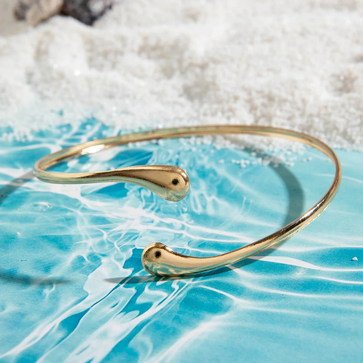 Gold-tone upper arm bracelet with smooth curved wire and small end studs