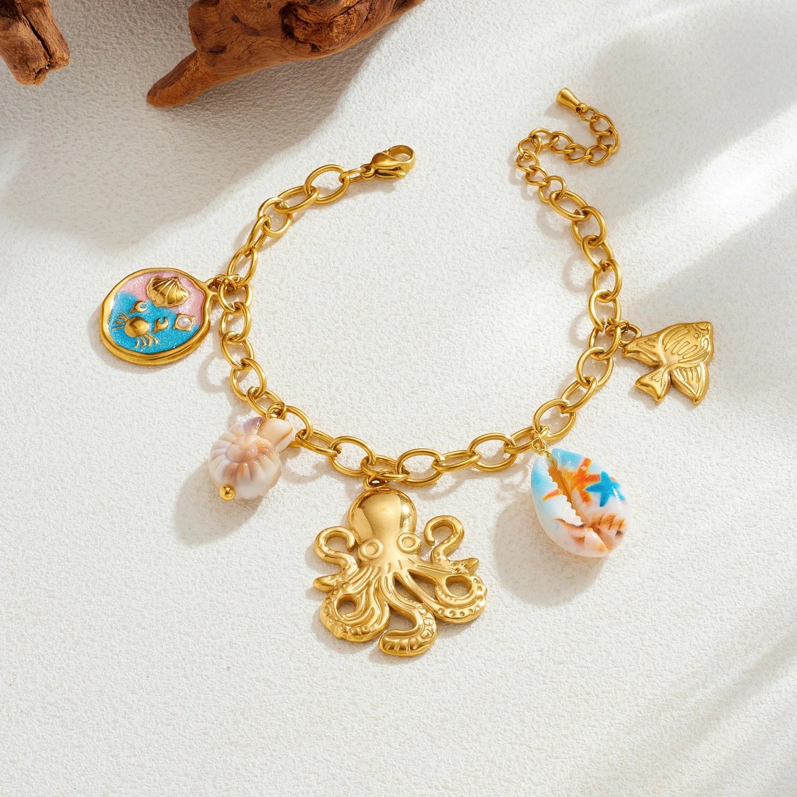 Gold-tone shell charm necklace with octopus pendant and blue enamel shell with fish drop.