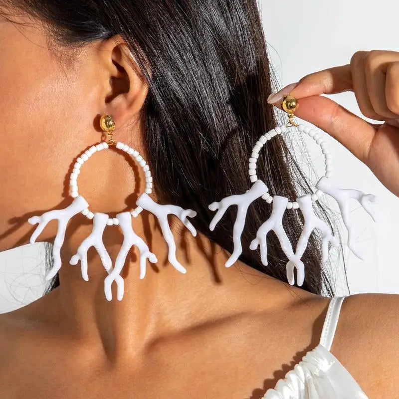 White acrylic drop earrings with circular bead hoops and flowing coral-like fringe