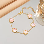 Gold flower bracelet with pink enamel clover charms and chain links