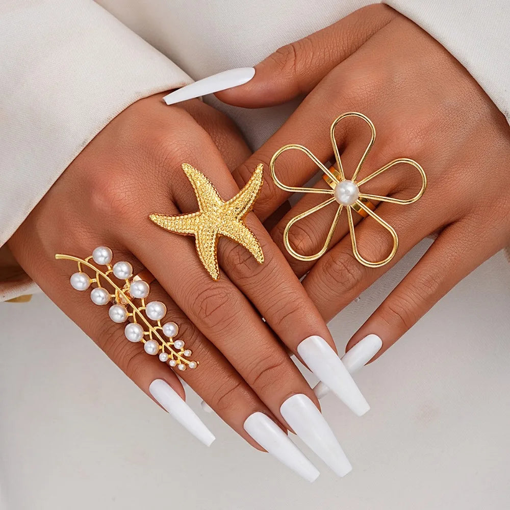 Gold-tone starfish ring with white pearl center on open loop band