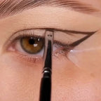Eyeliner and eyebrow makeup brush applying color along the eyebrow