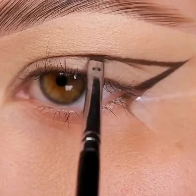Eyeliner and eyebrow makeup brush applying color along the eyebrow