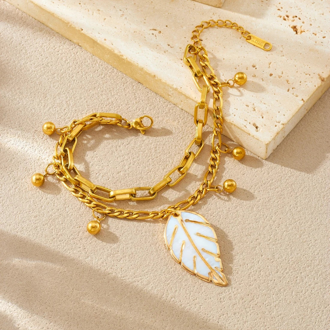Gold double-layer chain bracelet with leaf charm and dangling bead spheres