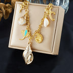 Gold-tone ocean necklace with conch-style shell, starfish, and seashell pendants
