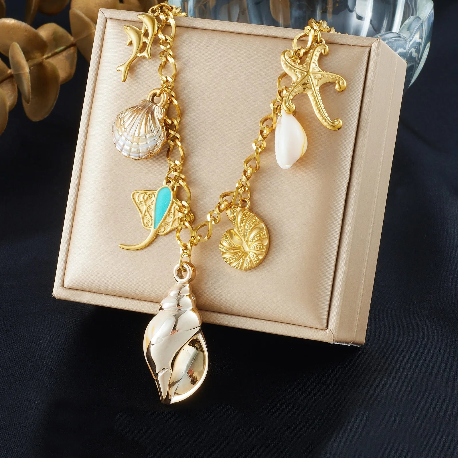 Gold-tone ocean necklace with conch-style shell, starfish, and seashell pendants