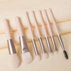 Makeup brushes with pale pink handles and silver ferrules, includes black spoolie