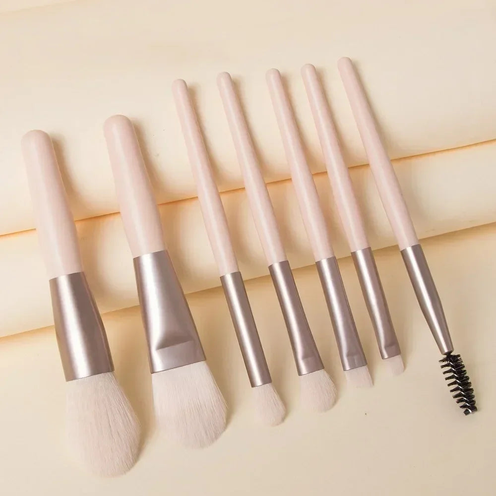 Makeup brushes with pale pink handles and silver ferrules, includes black spoolie