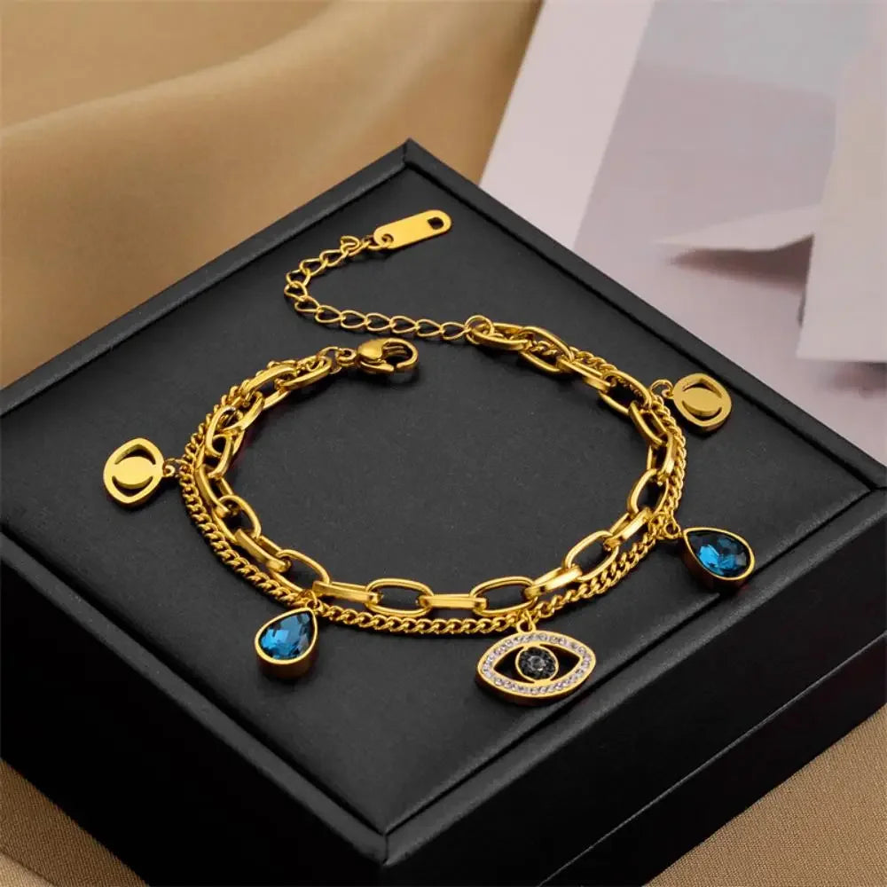 Gold-tone evil-eye double bangle bracelet with blue teardrop and eye pendants