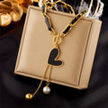 Gold-tone chain necklace with black heart charm and pearl-to-gold ball dangles