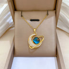 Gold-tone crescent moon pendant necklace with blue center and white rhinestone ring