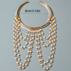 Gold-tone upper arm bracelet with pearl drops and layered chain tassels