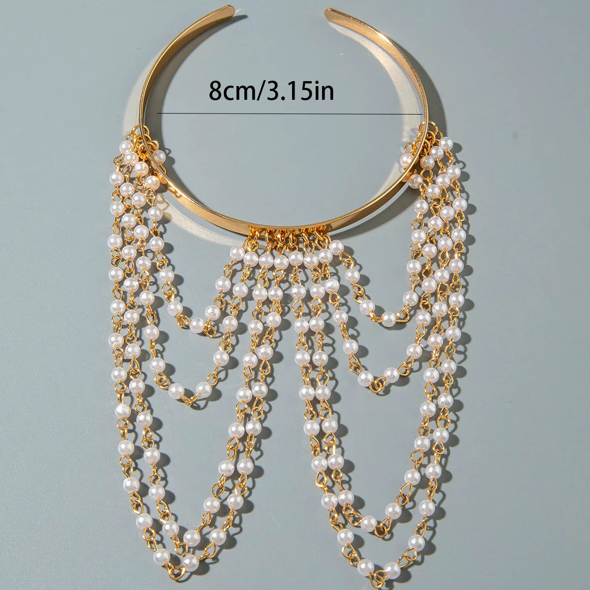 Gold-tone upper arm bracelet with pearl drops and layered chain tassels