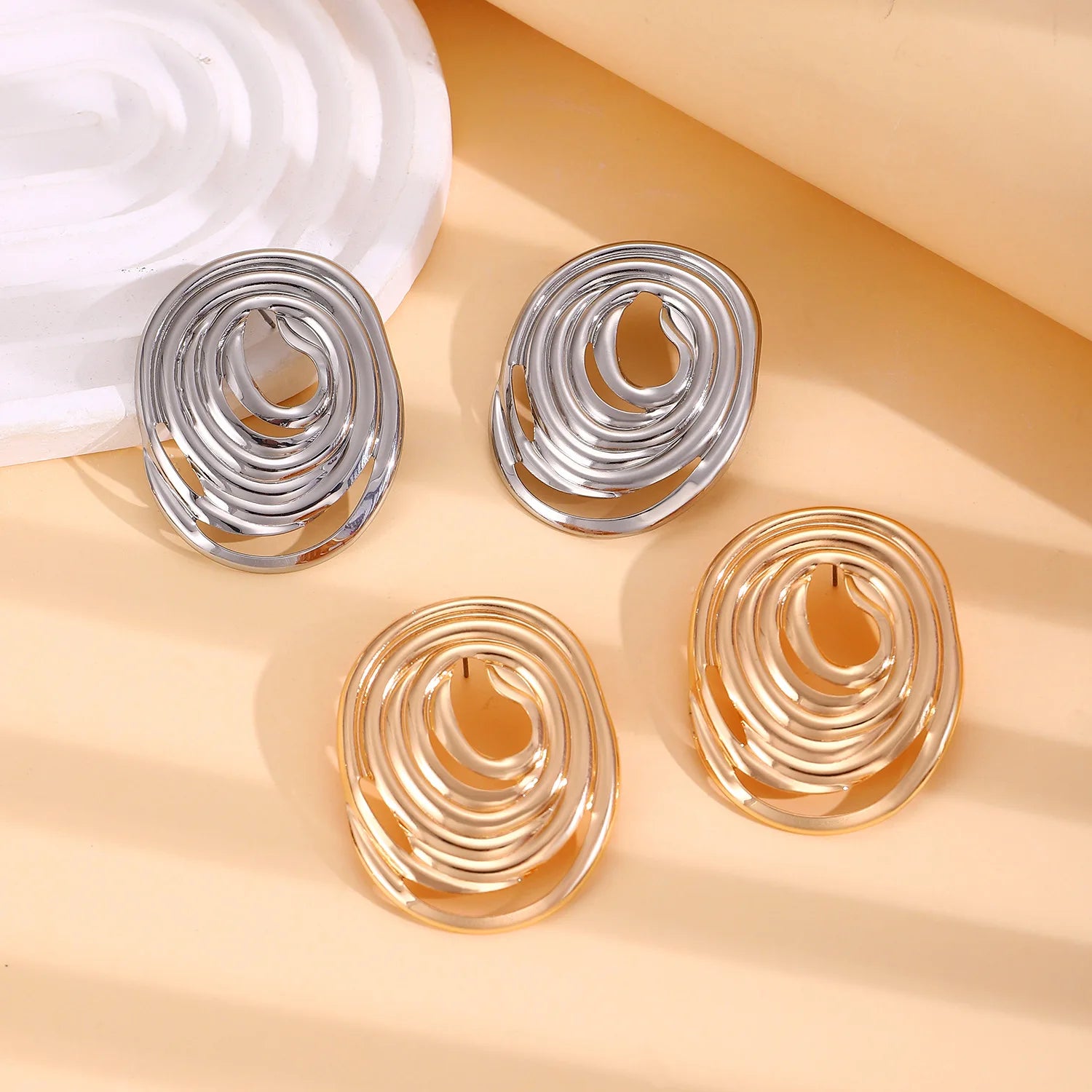 Gold and silver spiral hoop earrings with coiled center loops