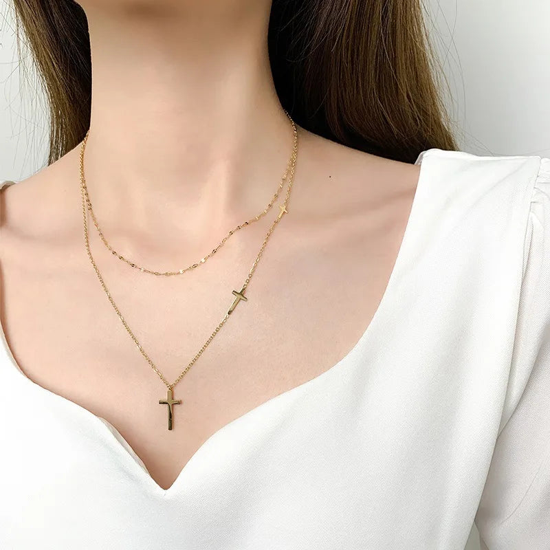 Double-layer gold cross pendant necklace with two cross charms on layered chains