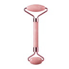 Facial massage roller with pink handle, oval top stone plate, and rounded base roller