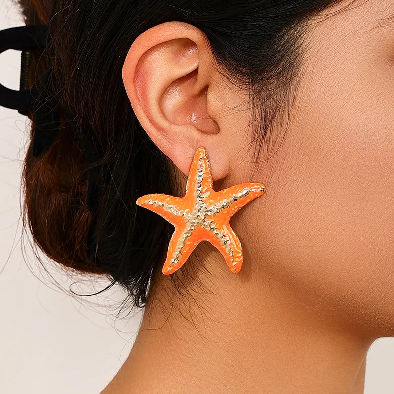 Starfish stud earrings with orange starfish and silver-tone textured accents