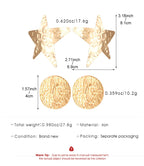Gold star and round textured drop earrings on a product size diagram