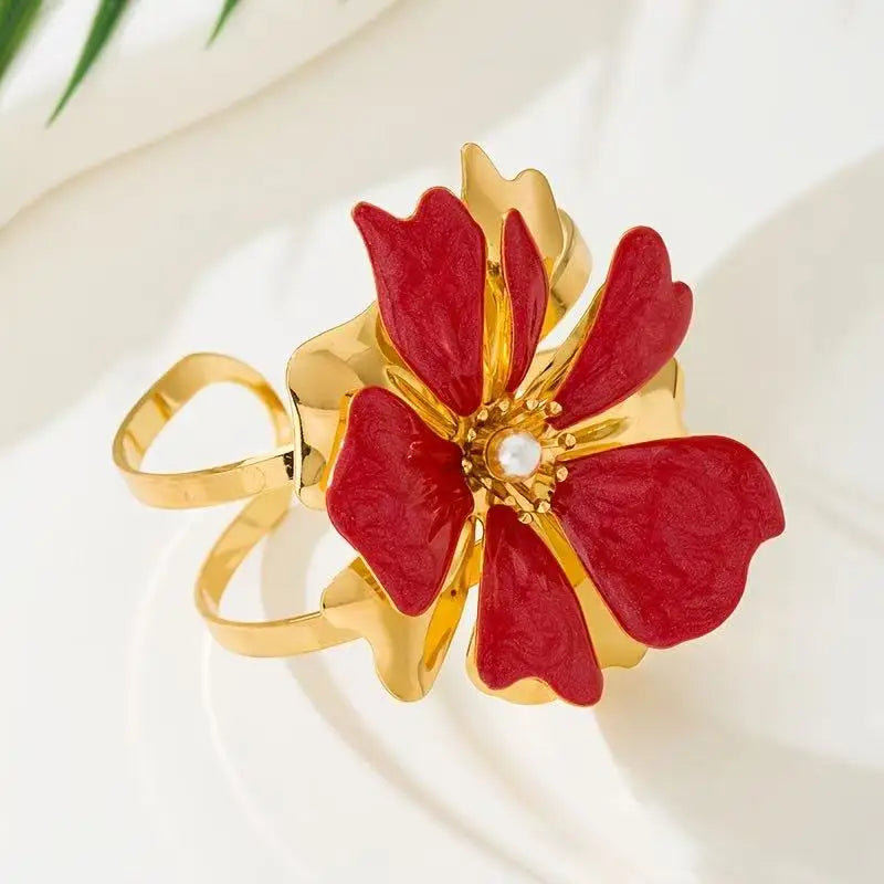 Flower cuff bangle bracelet with gold-tone band and red enamel flower with pearl center.