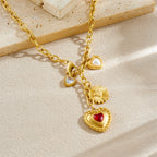 Gold tone pendant necklace with red heart charm, small white pearl hearts, and flower charm