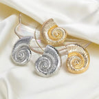 Mixed conch shell stud earrings in silver and gold tones with spiral centers