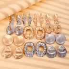 Assorted wrinkled gold and silver-tone drop earrings laid out on a display