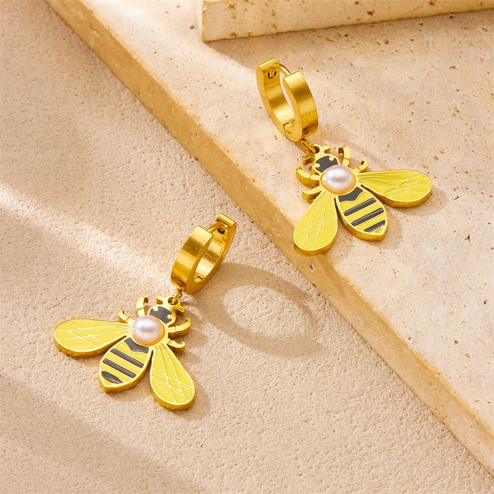 Gold-tone bee hoop earrings with pearl center and yellow enamel wings