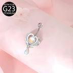 Curved barbell navel ring with heart centerpiece, teardrop charm, and clear crystal accents