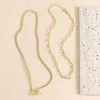 Gold layered chain necklace set shown with oval connector at the front