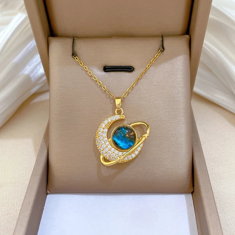 Gold-tone crescent moon pendant necklace in box, blue center with white rhinestones