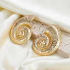Gold conch shell stud earrings with spiral center, textured shell design.