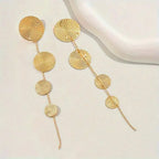 Gold-tone woven disc dangle earrings with four round circles and long thin tail tassels