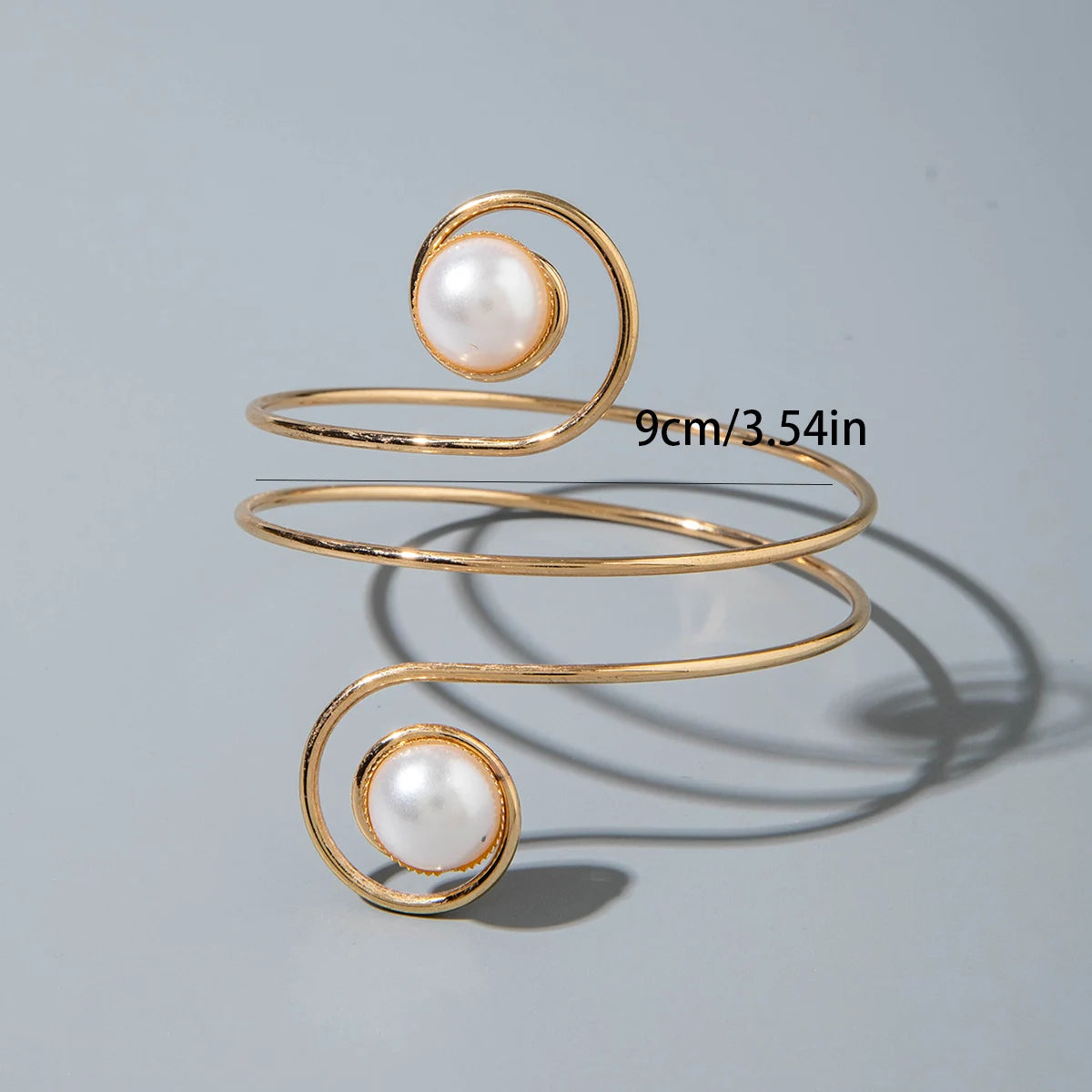 Gold-tone upper arm bracelet with spiral wire and round pearl stone accents