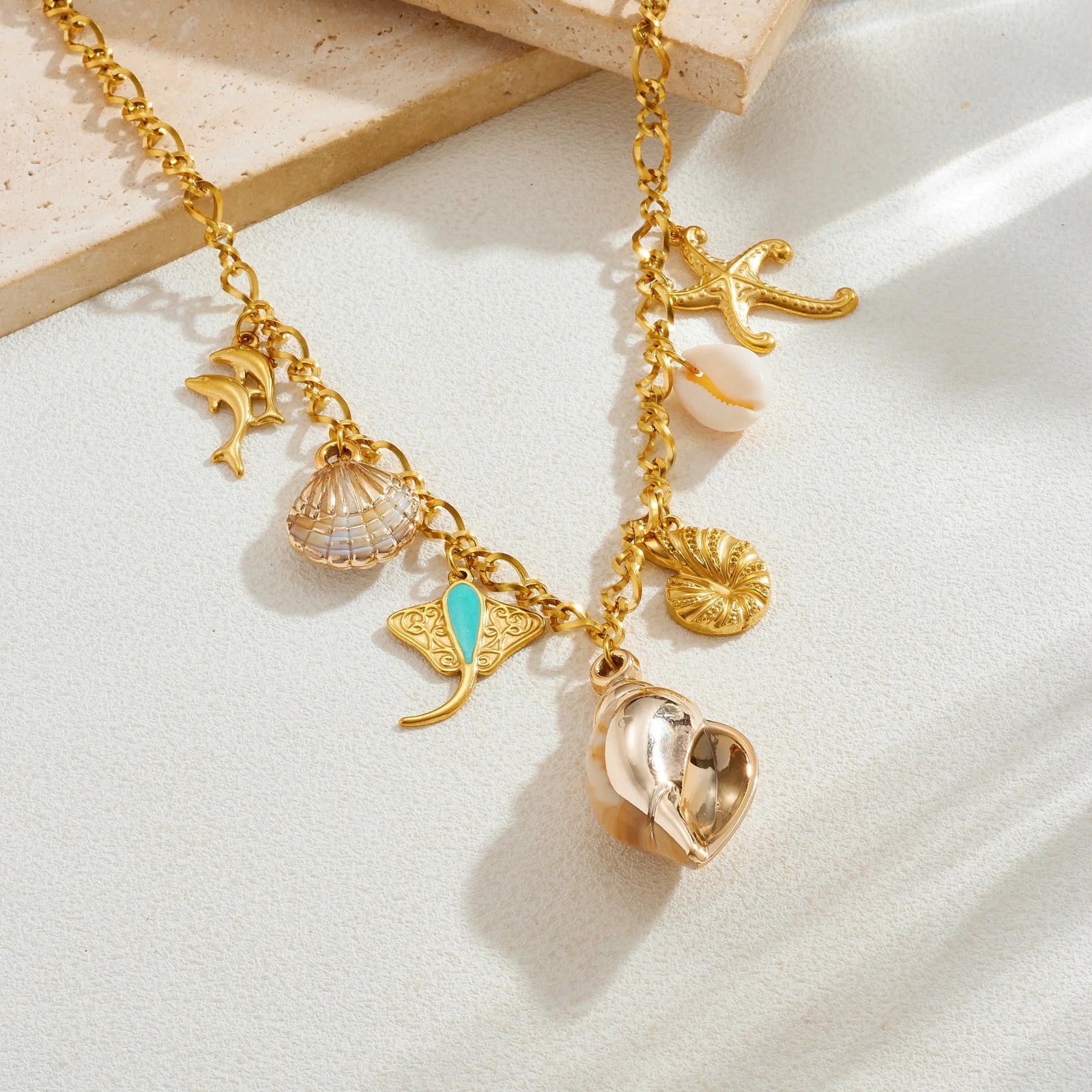 Gold-tone ocean necklace with conch-style shell pendant, starfish, seahorse, and shell charms