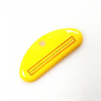 Yellow toothpaste tube squeezer dispenser with long slotted opening and side hole