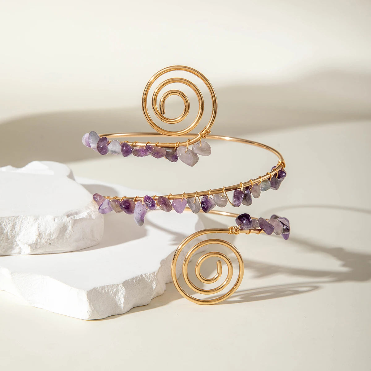 Gold-tone upper arm bracelet set with spiral motif and purple stone bead fringe