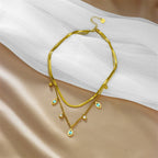 Gold-tone double-layer snake chain necklace with blue evil-eye charms and small round beads