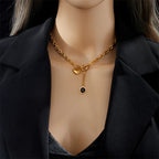 Heart pendant necklace with gold-tone chain, heart charm and round black stone drop